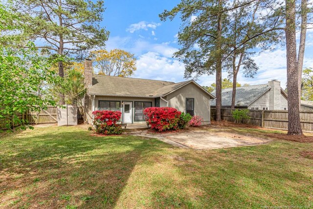 5516 Deep Hollow Ct, Fayetteville, NC 28311 - rear view of house with a chimney, a yard, a patio, and a fenced backyard