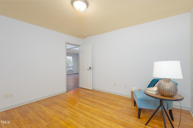 living area featuring baseboards and light wood-type flooring