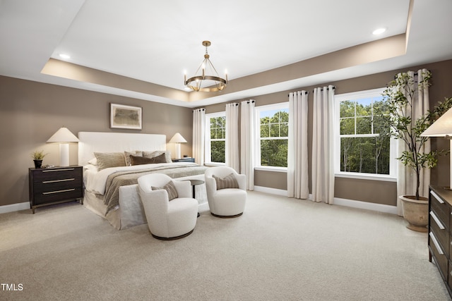 bedroom featuring a tray ceiling, an inviting chandelier, light carpet, and baseboards
