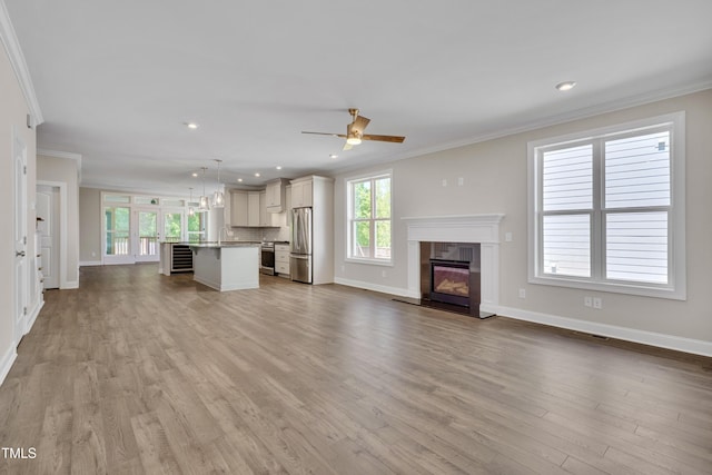 127 Post Oak Rd, Chapel Hill, NC 27516 - unfurnished living room featuring crown molding, a glass covered fireplace, baseboards, wood finished floors, and recessed lighting