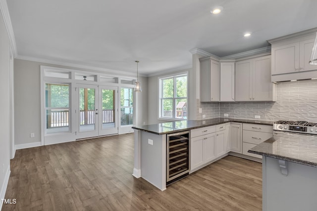 127 Post Oak Rd, Chapel Hill, NC 27516 - kitchen with wine cooler, stainless steel gas range, crown molding, tasteful backsplash, and light wood-style flooring