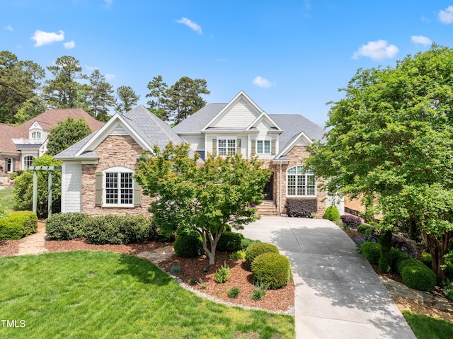 view of front of house with a front yard and stone siding