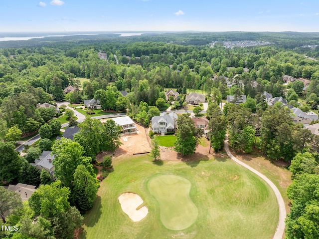 drone / aerial view with view of golf course, a residential view, and a forest view