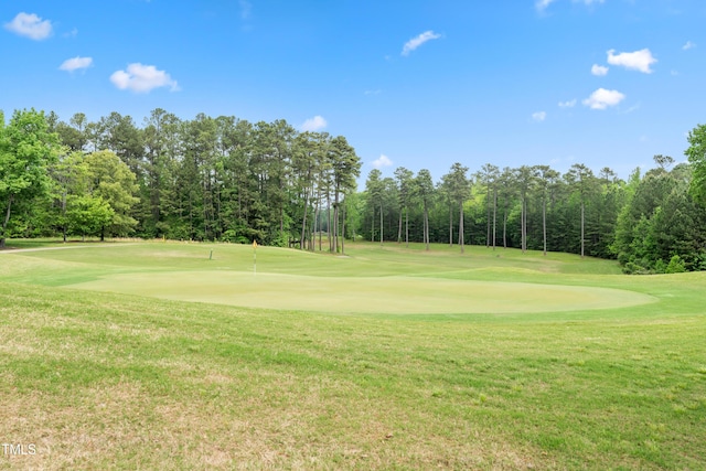 view of community with a yard and view of golf course