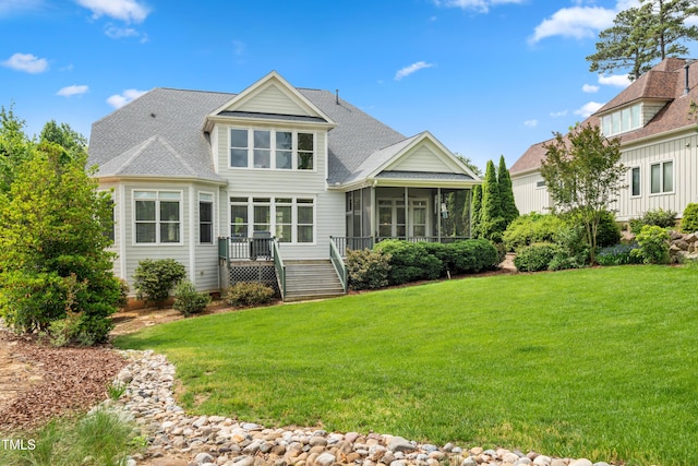 back of house with a wooden deck, a sunroom, a shingled roof, a lawn, and stairway