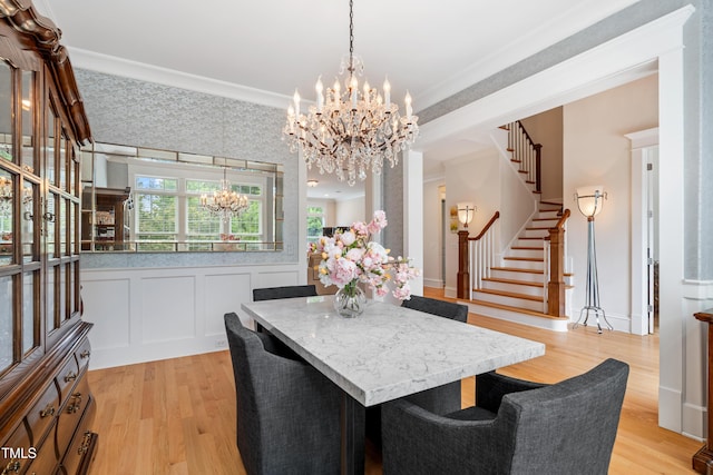 dining room with stairway, ornamental molding, light wood finished floors, and a chandelier
