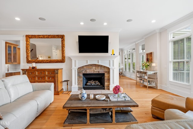 living area featuring light wood-style floors, baseboards, plenty of natural light, and a fireplace