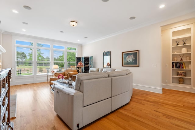 living area with built in shelves, baseboards, ornamental molding, recessed lighting, and light wood-style flooring