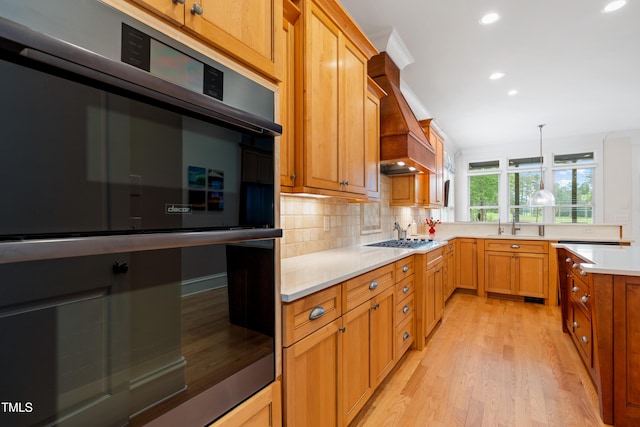 kitchen with recessed lighting, stainless steel double oven, light wood-style flooring, and decorative backsplash