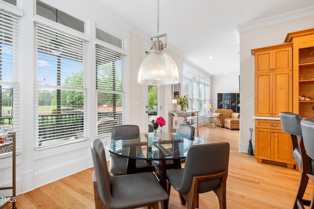 dining room featuring light wood-style floors, ornamental molding, and recessed lighting