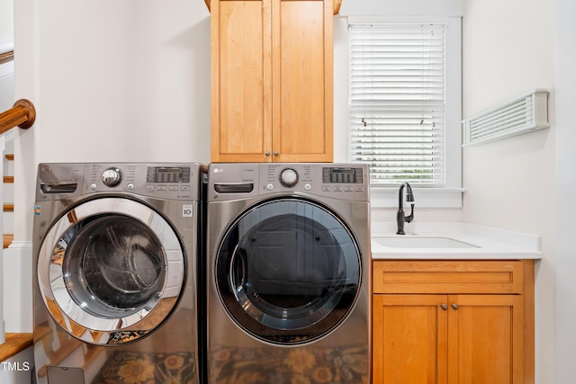 laundry room with a sink, cabinet space, and washing machine and dryer