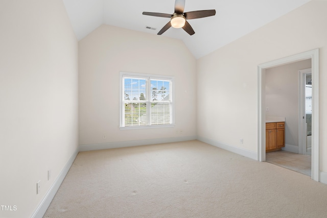 unfurnished bedroom featuring visible vents, lofted ceiling, light carpet, baseboards, and connected bathroom