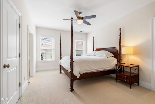 bedroom featuring light colored carpet, a ceiling fan, and baseboards