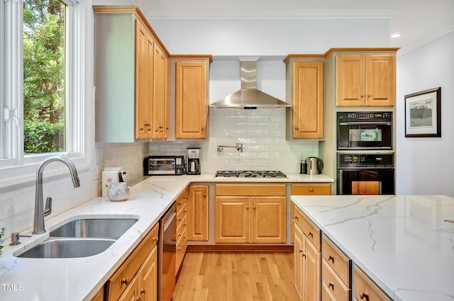 kitchen with crown molding, wall chimney exhaust hood, dishwasher, a sink, and light wood-style flooring