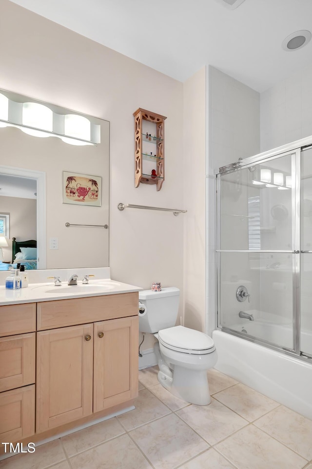 ensuite bathroom featuring tile patterned floors, vanity, toilet, and ensuite bath