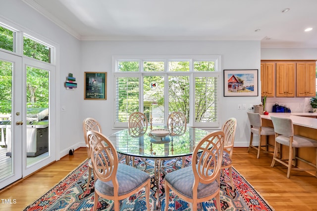 dining area featuring light wood-type flooring, recessed lighting, baseboards, and crown molding