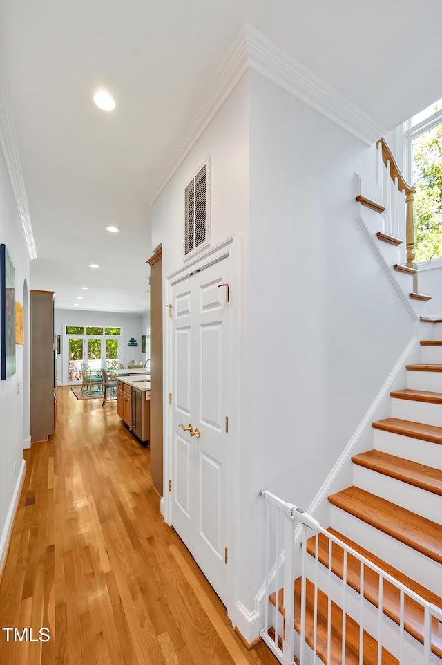 corridor featuring recessed lighting, visible vents, a healthy amount of sunlight, and light wood-style floors