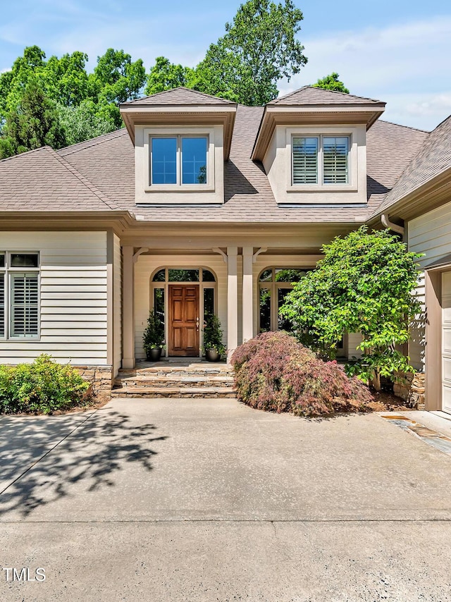doorway to property with roof with shingles