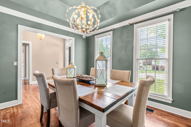 8600 Clivedon Dr, Raleigh, NC 27615 - dining room with baseboards, ornamental molding, wood finished floors, and a notable chandelier
