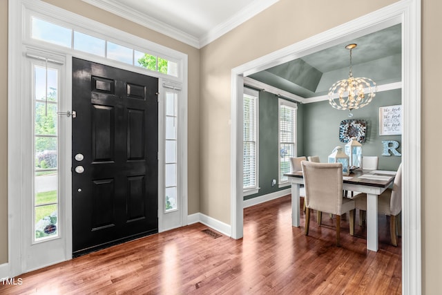 8600 Clivedon Dr, Raleigh, NC 27615 - foyer featuring visible vents, ornamental molding, wood finished floors, baseboards, and a chandelier
