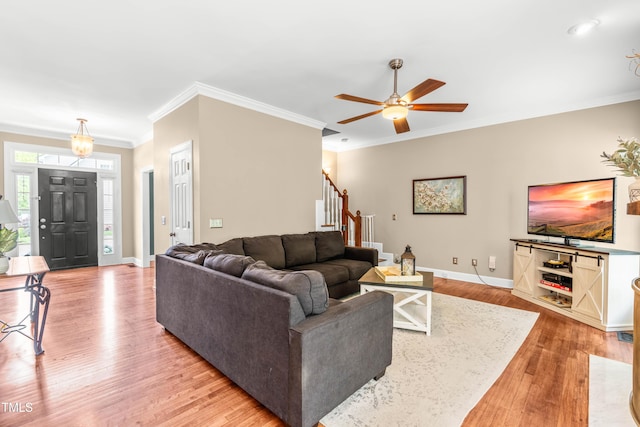 8600 Clivedon Dr, Raleigh, NC 27615 - living room featuring ceiling fan, light wood-style flooring, baseboards, ornamental molding, and stairway