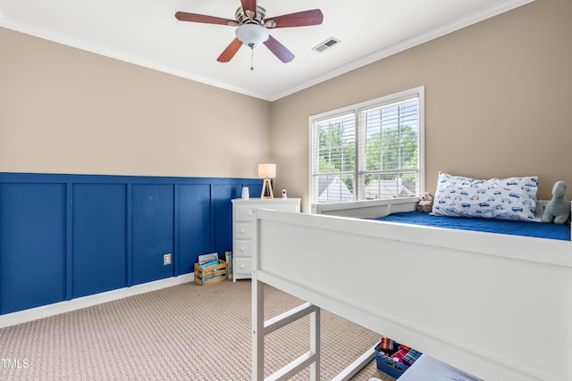 8600 Clivedon Dr, Raleigh, NC 27615 - bedroom featuring visible vents, crown molding, wainscoting, a decorative wall, and light carpet