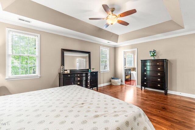 8600 Clivedon Dr, Raleigh, NC 27615 - bedroom with dark wood finished floors, baseboards, a tray ceiling, visible vents, and ornamental molding