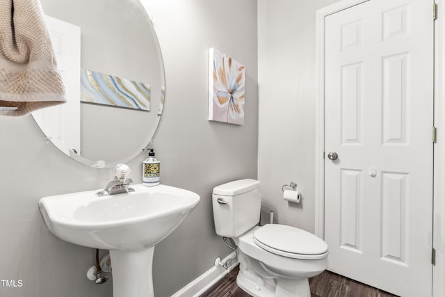 8600 Clivedon Dr, Raleigh, NC 27615 - half bath with baseboards, a sink, wood finished floors, and toilet