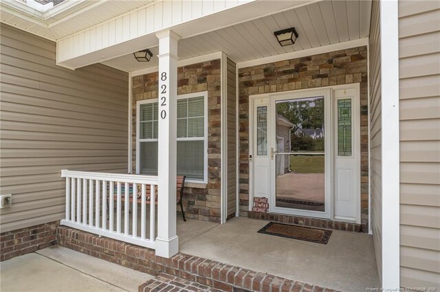 8220 Rivermist Ln, Linden, NC 28356 - doorway to property featuring a porch and stone siding