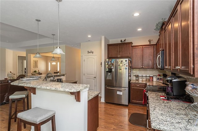 8220 Rivermist Ln, Linden, NC 28356 - kitchen with backsplash, a kitchen bar, appliances with stainless steel finishes, and dark wood finished floors