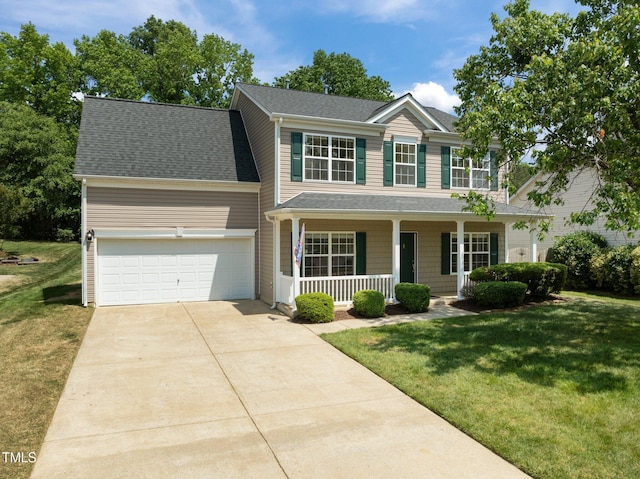 colonial inspired home featuring covered porch, roof with shingles, a front yard, a garage, and concrete driveway