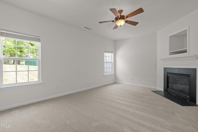 unfurnished living room featuring baseboards, a fireplace with flush hearth, carpet, and visible vents