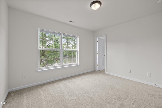 carpeted empty room featuring baseboards and visible vents
