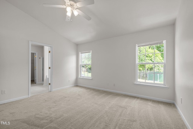 spare room with baseboards, ceiling fan, light carpet, and lofted ceiling