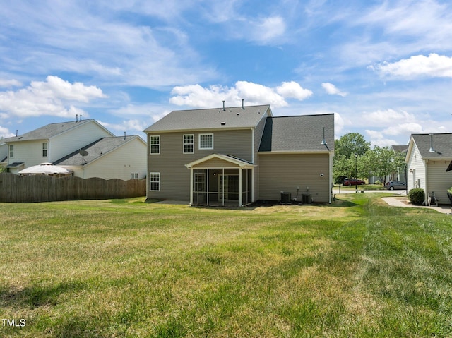 back of house with a lawn, a sunroom, central air condition unit, fence, and a shingled roof