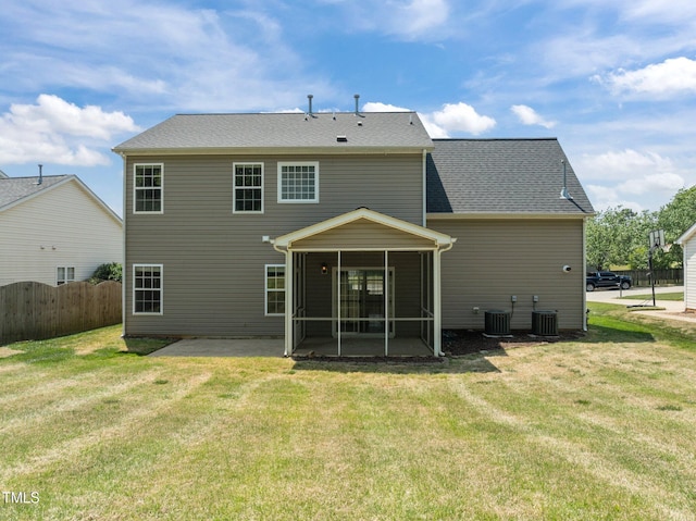 back of property with a lawn, fence, and a sunroom