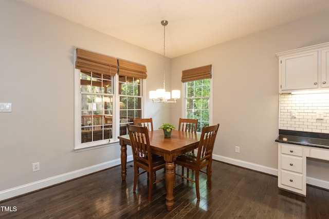 dining area featuring dark wood-style floors, baseboards, and a chandelier