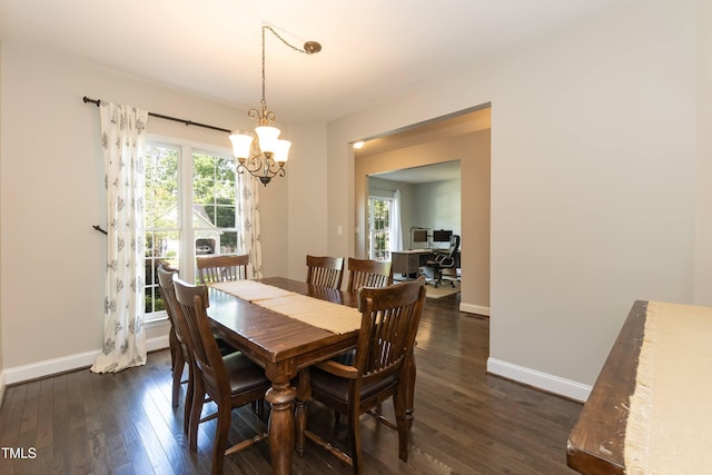 dining area featuring a chandelier, dark wood-style floors, and baseboards
