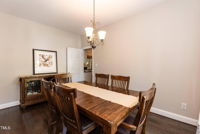 dining area featuring baseboards, a chandelier, and dark wood-style flooring