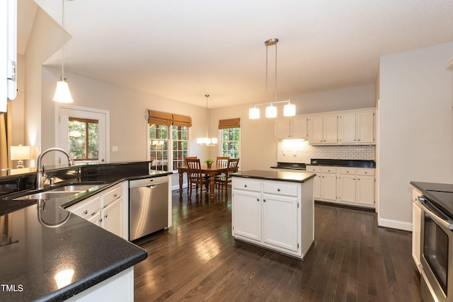 kitchen featuring dishwasher, a sink, dark countertops, range with electric stovetop, and white cabinetry