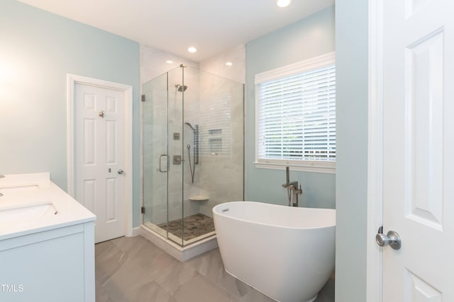 bathroom with a stall shower, a freestanding bath, double vanity, and recessed lighting