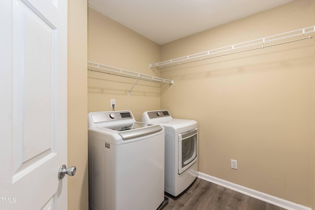 washroom with washer and clothes dryer, dark wood-style floors, and baseboards