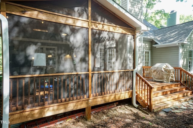 view of side of property featuring a chimney, a shingled roof, and a deck