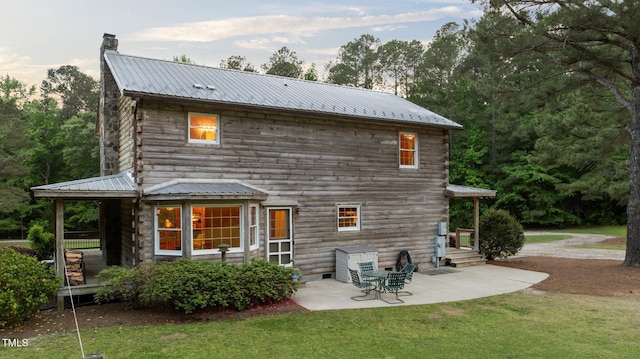 407 Howard Tant Rd, Zebulon, NC 27597 - back of property with a patio, metal roof, a chimney, entry steps, and a lawn