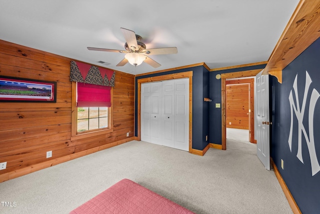 407 Howard Tant Rd, Zebulon, NC 27597 - unfurnished bedroom featuring visible vents, baseboards, a closet, wooden walls, and carpet