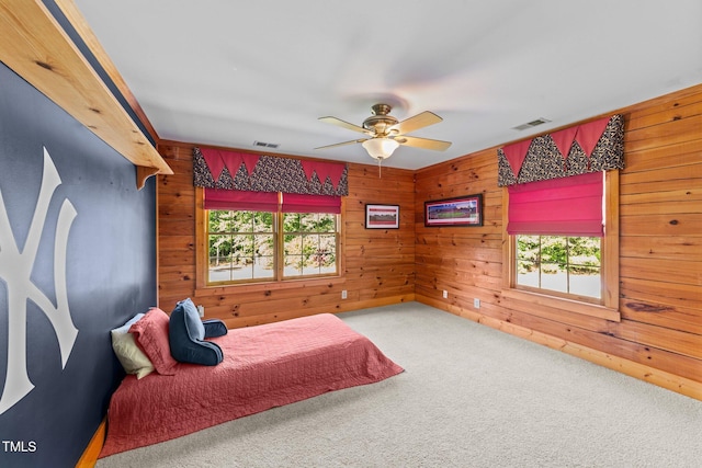 407 Howard Tant Rd, Zebulon, NC 27597 - bedroom with visible vents, carpet flooring, a ceiling fan, and wooden walls
