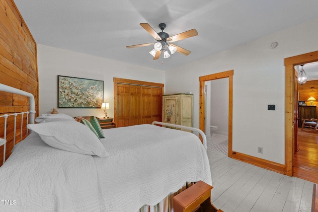 407 Howard Tant Rd, Zebulon, NC 27597 - bedroom featuring wooden walls, ceiling fan, baseboards, wood finished floors, and a closet