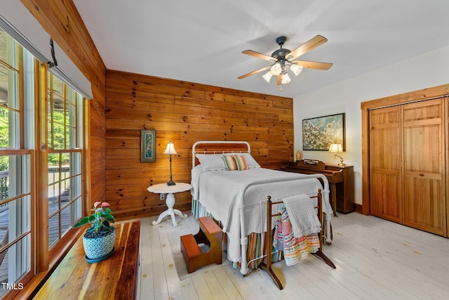 407 Howard Tant Rd, Zebulon, NC 27597 - bedroom featuring wooden walls, ceiling fan, and light wood-style flooring