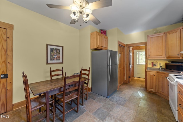 407 Howard Tant Rd, Zebulon, NC 27597 - kitchen with light brown cabinetry, stone finish floor, ceiling fan, and stainless steel appliances