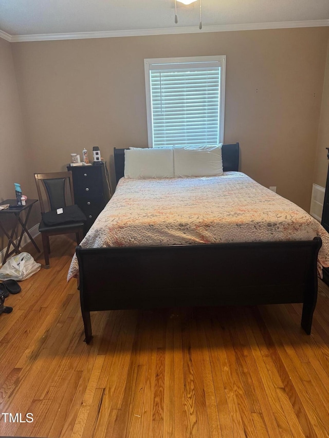 bedroom with crown molding and light wood-type flooring